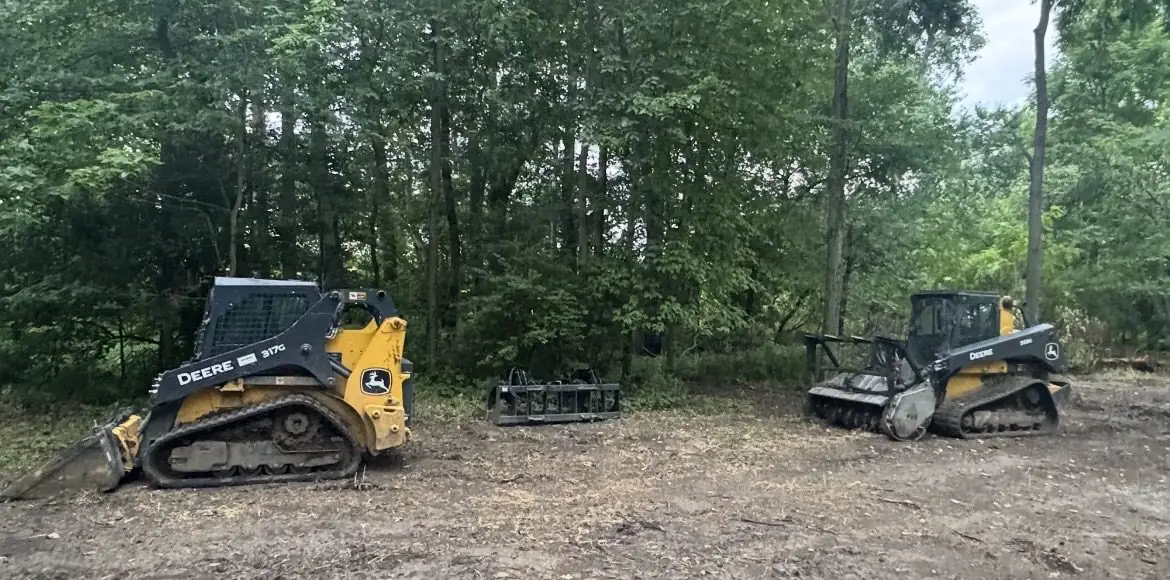 Skid steers with forestry attachments in the woods near Dayton, OH
