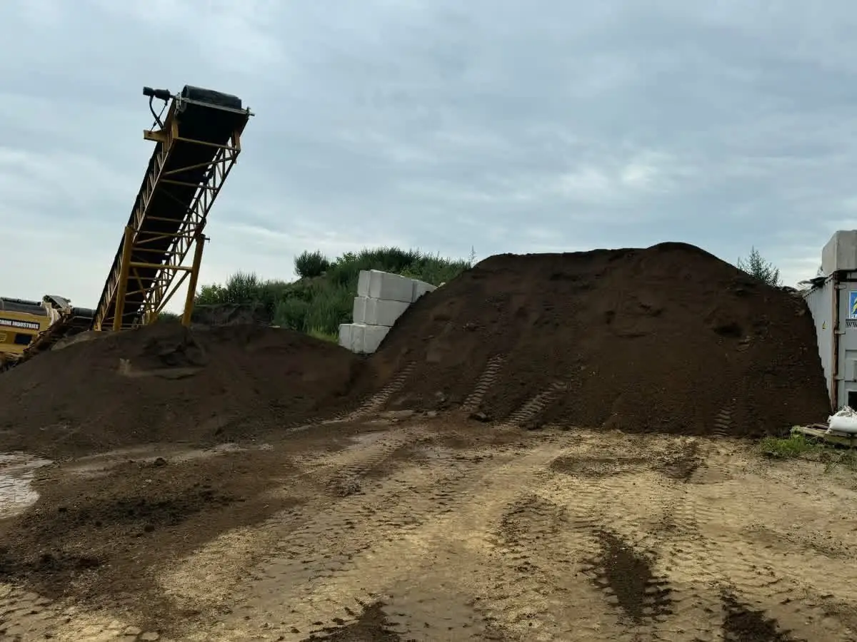 Conveyor building a pile of blended topsoil